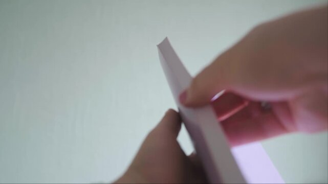 Close up of hands quickly flipping book pages on green background example of fast reading and study process