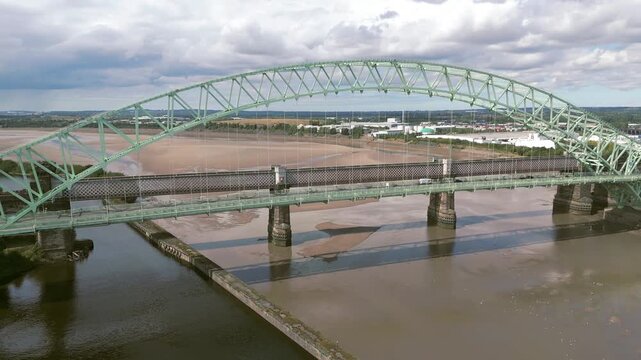 Liverpool, Merseyside, UK, September 09, 2025; aerial 4K video footage of the Silver Jubilee Bridge and Britannia Railway Viaduct over the River Mersey and Manchester Ship Canal, Runcorn, Merseyside