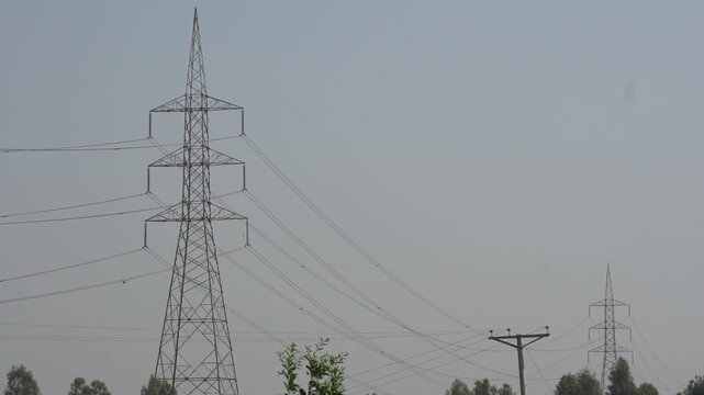 High voltage electricity transmission towers and power lines in a rural landscape
