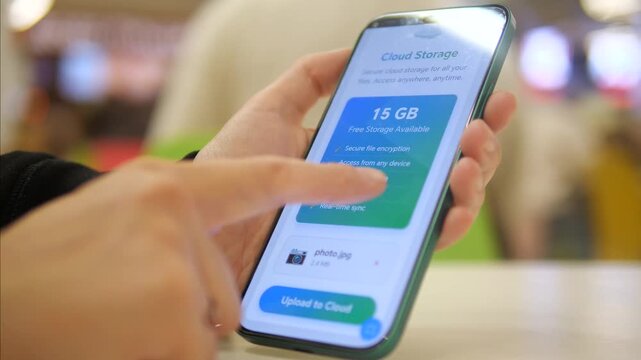 Person interacting with a secure cloud storage mobile app. Interface highlights 15GB free space, data encryption, and automatic backup features. Perfect for tech, cybersecurity, and digital lifestyle