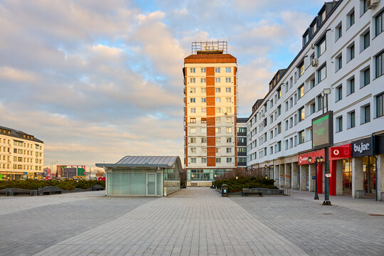 Urban plaza with modern buildings and shops under cloudy sky. March 3, 2026, Suceava Romania