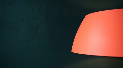 Minimalist Interior Detail Featuring a Glowing Orange Lampshade Against a Deep Teal Wall.