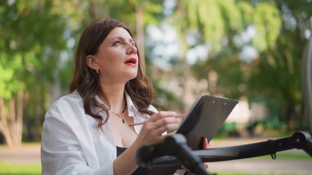 Woman reviews schedule with checklist. Mother balances work responsibilities and parenting priorities effectively. Mother uses tablet and checklist to organize her day efficiently and thoughtfully