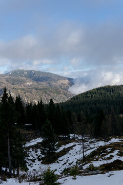 Snowy mountain peak landscape with fog and clouds. Background for travel and winter tourism