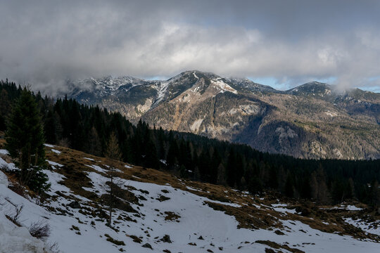 Snowy mountain peak landscape with fog and clouds. Background for travel and winter tourism