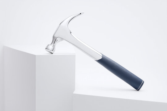 Martillo met&aacute;lico cromado con mango de cuero azul oscuro en estudio blanco, Mockup de martillo premium en plataforma blanca para branding, Herramienta elegante para proyectos de dise&ntilde;o o construcci&oacute;n 