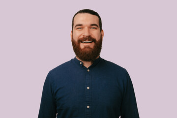 Fototapeta premium Smiling White Man Closeup Direct Gaze, Navy Shirt, Warm Friendly Expression, Soft Pink Background, Polished