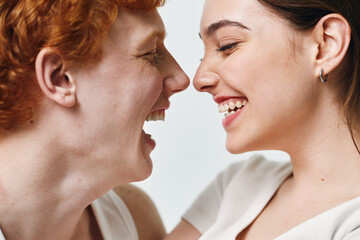 Fototapeta premium Couple laughing and looking at each other with joy and happiness closeup. Young man and woman enjoying moment of togetherness and love in casual style.