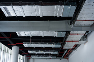Naklejka premium Exposed industrial ceiling with ventilation ducts metal framework and insulation layers