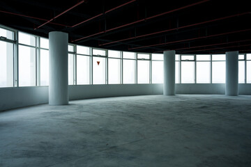 Naklejka premium Spacious modern office interior with floor-to-ceiling windows and concrete columns