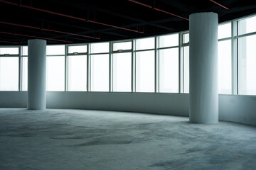 Naklejka premium Spacious empty office interior with floor-to-ceiling windows and concrete columns