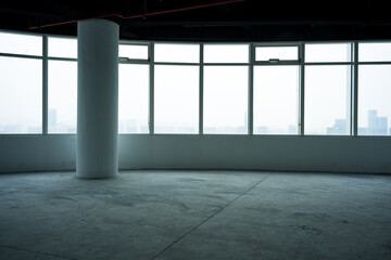 Naklejka premium Empty modern office space with floor-to-ceiling windows overlooking city skyline