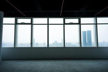 Empty office space with floor-to-ceiling windows overlooking urban skyline and modern high-rise buildings © zhu difeng