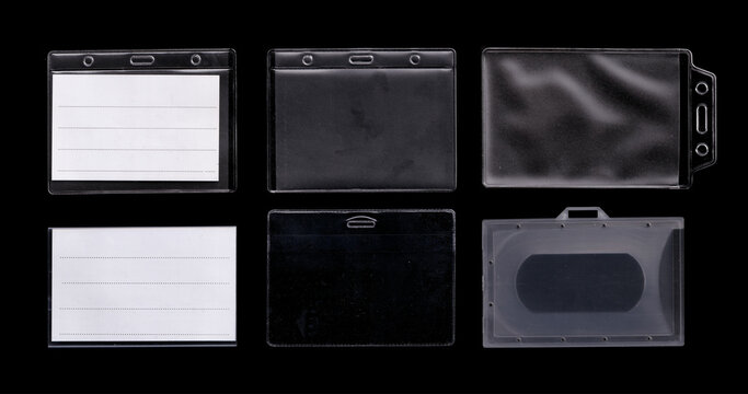 Plastic ID Badge Holders with Blank Inserts on Black Background. Assorted clear and black plastic ID badge holders with blank label cards, isolated on black. Photo