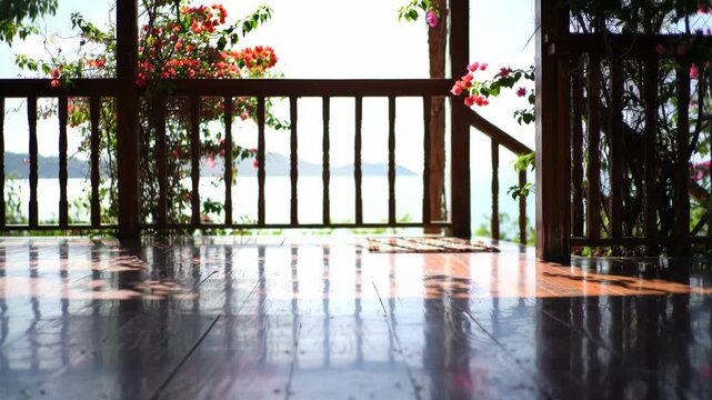 Ocean view from wooden deck with railing and flowers. Tropical island getaway, vacation.