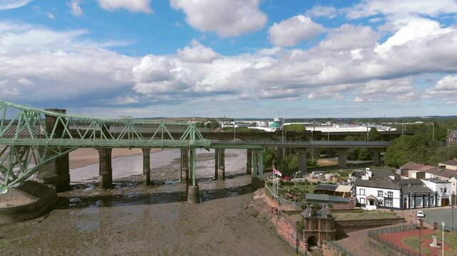 Liverpool, Merseyside, UK, September 09, 2025; aerial 4K video footage of the Silver Jubilee Bridge and Britannia Railway Viaduct over the River Mersey and Manchester Ship Canal, Runcorn, Merseyside