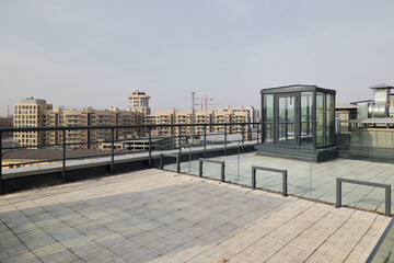 Fototapeta premium Spacious urban rooftop with glass elevator and skyline vista