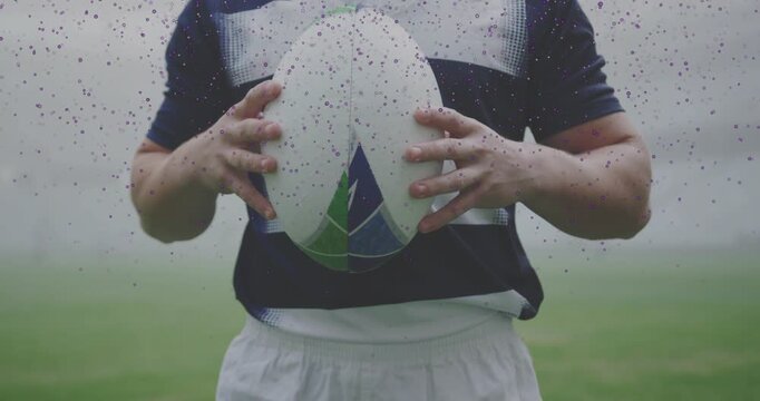 Camera zooming in misty field navy-white rugby player holding ball preparing to pass for training