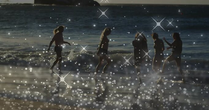 Five women wading into surf as waves coming in, sparkling overlay framing shapes bonding for travel