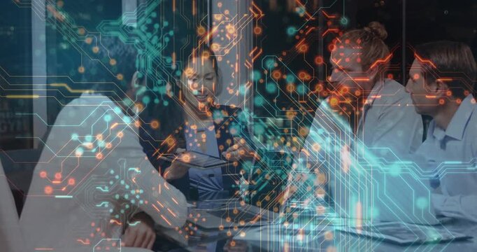 Tech team tapping tablet and pointing papers at table, initiating circuit overlay growth for review