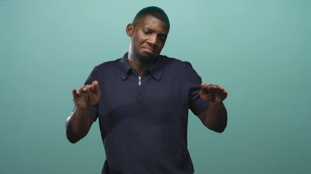 Man shows hands out palms forward pushing gesture in studio wearing navy polo and zipper collar; hesitation disgust.