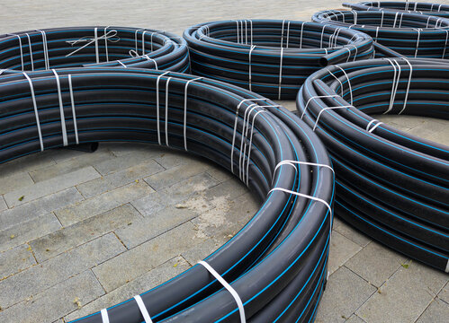 Coils of HDPE pipes were unloaded at a construction site.