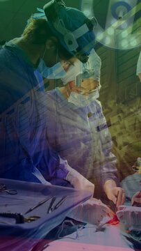 Vertical video: Surgeons responding to monitor alarm, operating in OR with vitals overlaying tools