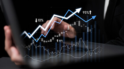 A business professional engages with financial data on a laptop, highlighting upward trends in...