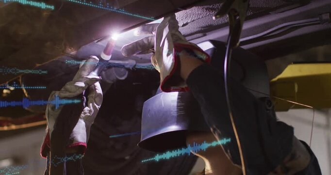 Welder raising torch, igniting arc, welding, repairing auto underbody, blue HUD waves overlaying
