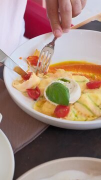 Homemade ravioli pasta italian cuisine hands cutting a piece. Dumpling filled cheese tortellini. High quality FullHD footage