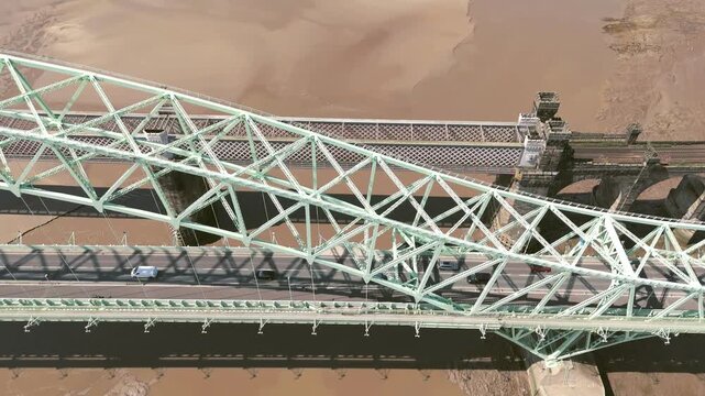 Liverpool, Merseyside, UK, September 09, 2025; aerial 4K video footage of the Silver Jubilee Bridge and Britannia Railway Viaduct over the River Mersey and Manchester Ship Canal, Runcorn, Merseyside