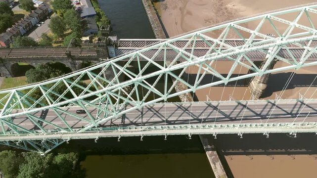 Liverpool, Merseyside, UK, September 09, 2025; aerial 4K video footage of the Silver Jubilee Bridge and Britannia Railway Viaduct over the River Mersey and Manchester Ship Canal, Runcorn, Merseyside