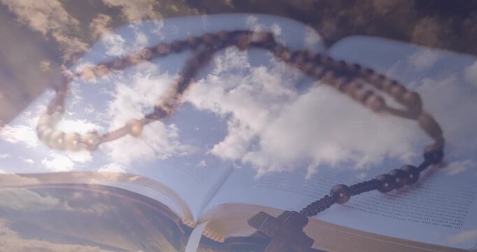 Rosary beads resting across open book, overlay shifting to reveal drifting clouds for calm mood