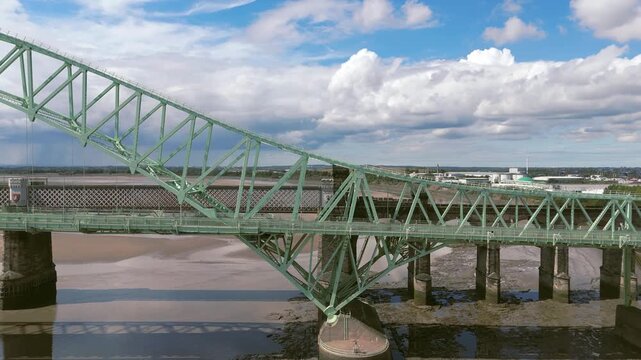 Liverpool, Merseyside, UK, September 09, 2025; aerial 4K video footage of the Silver Jubilee Bridge and Britannia Railway Viaduct over the River Mersey and Manchester Ship Canal, Runcorn, Merseyside
