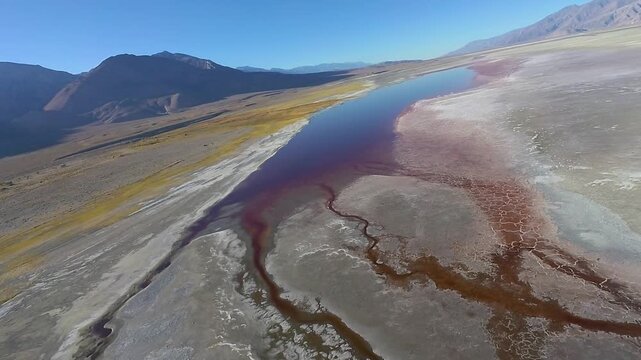 Colorful and dramatic low flyby of a deep red, nearly dry portion of Owens Lake in eastern California's scenic Owens Valley, with views of the Sierra Nevada and Inyo Mountains.