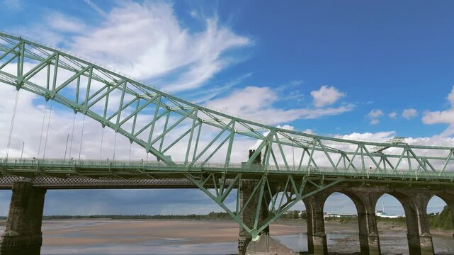 Liverpool, Merseyside, UK, September 09, 2025; aerial 4K video footage of the Silver Jubilee Bridge and Britannia Railway Viaduct over the River Mersey and Manchester Ship Canal, Runcorn, Merseyside