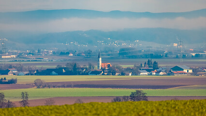 Winter landscape on a sunny day with the church of Kirchdorf in the distance seen from near Ramsdorf, Wallerfing, Deggendorf, Bavaria, Germany