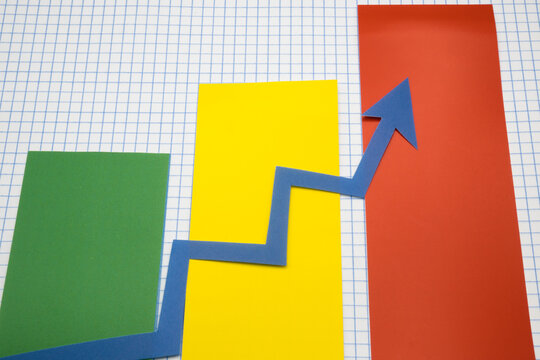 Arrows cut out of colored paper imitating a graphic chart of increase or decrease.
