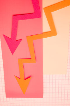 Arrows cut out of colored paper imitating a graphic chart of increase or decrease.
