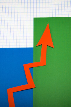 Arrows cut out of colored paper imitating a graphic chart of increase or decrease.
