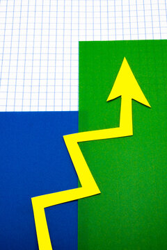 Arrows cut out of colored paper imitating a graphic chart of increase or decrease.
