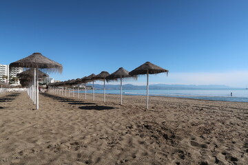 Fototapeta premium Sun Umbrellas Lined Up on Benalmádena Beach, Costa del Sol, Spain