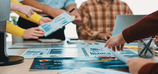 A dynamic team working together in a bright office space, engaging in discussion around documents...