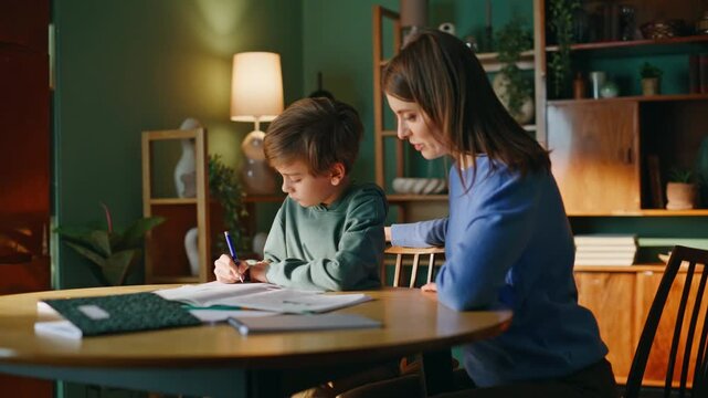 Woman tutor supervising pupil learning homework home. Mother supporting student