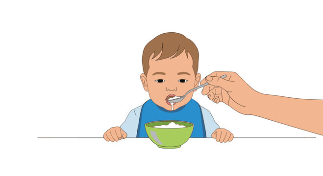 A baby with brown hair and a blue bib sits at a white table being spoon-fed white food by an adult's hand.
