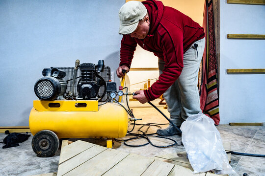 Man starting the air compressor with your hand in garage.