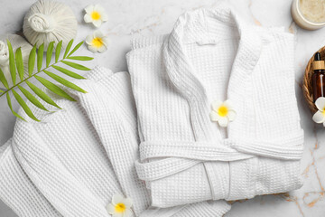 Naklejka premium Flat lay composition with bathrobes and spa products on white marble table