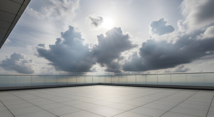 Fototapeta premium Expansive rooftop terrace with modern glass railings overlooking a dramatic cloudy sky and distant horizon, bathed in sunlight