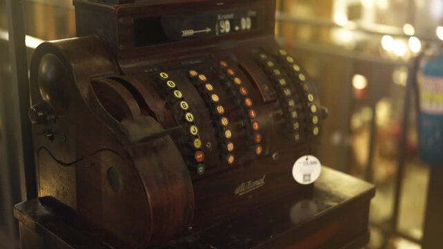 Antique rusty cash register  with wooden handle stands on a shelf