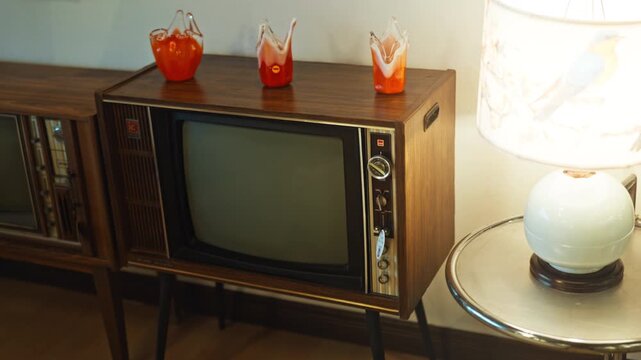 A dark retro styled room with old home appliances and a cathode ray tube TV.